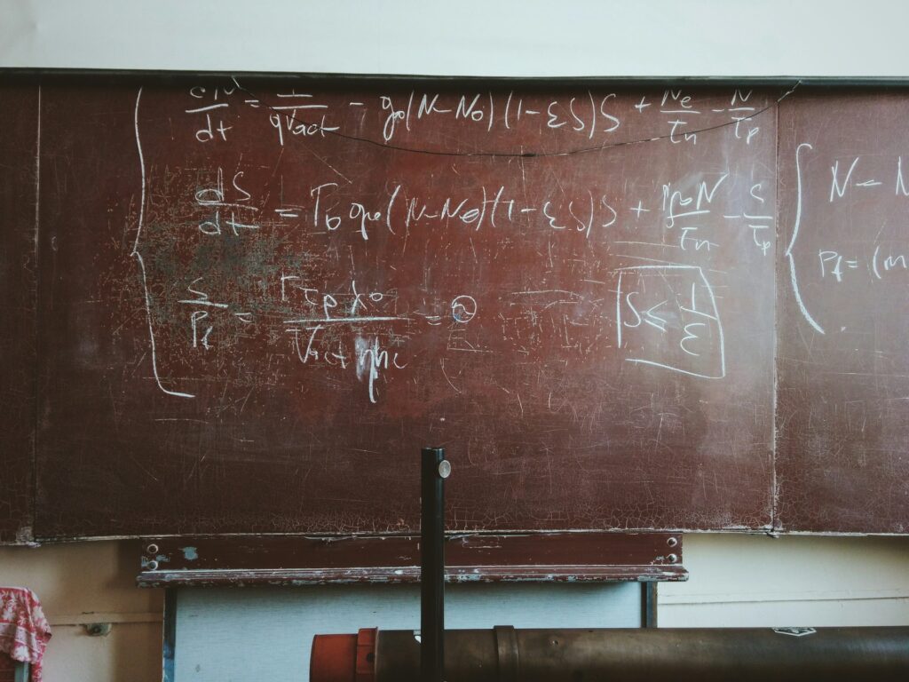 A dusty blackboard filled with complex physics equations, illustrating an academic or research setting in physics.