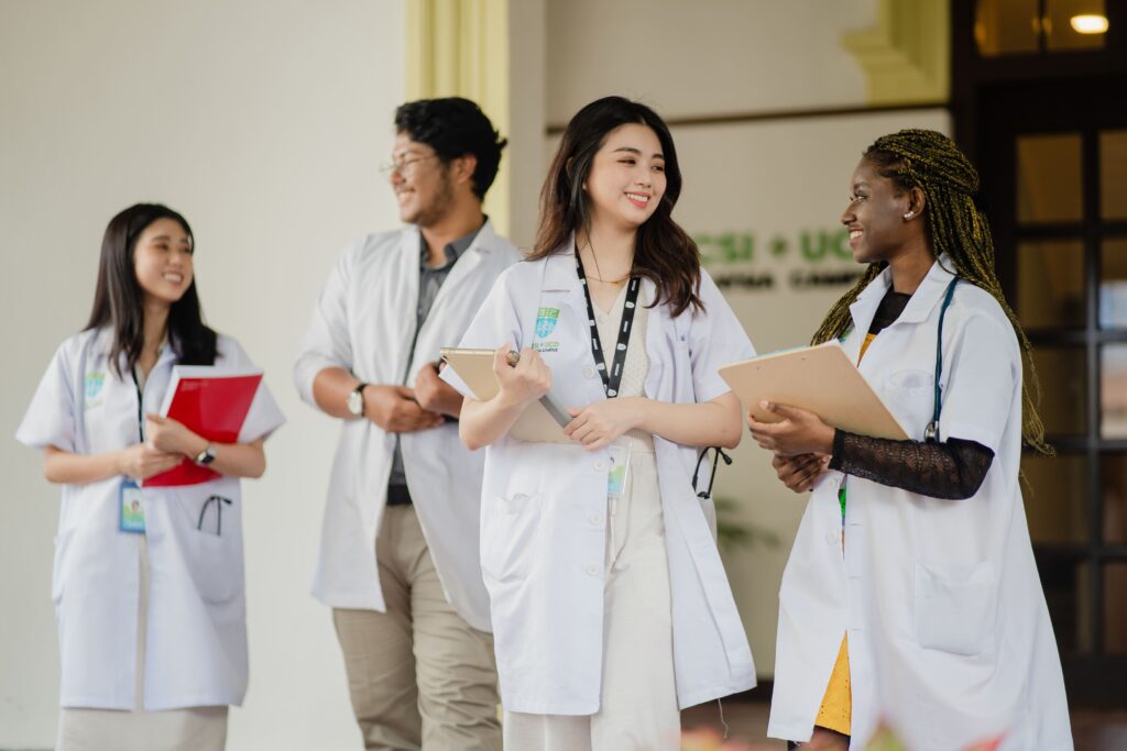 Four medical students in lab coats standing in the RUMC campus.